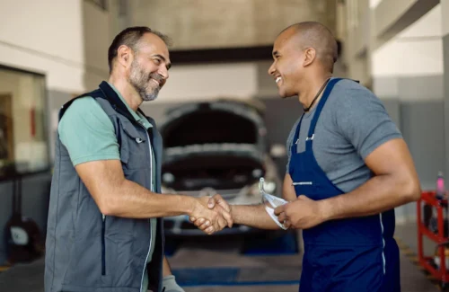 happy-mechanic-greeting-with-his-african-american-coworker-auto-repair-shop_637285-11601